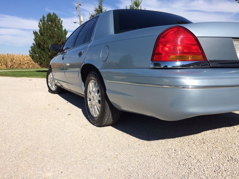 Light blue 2003 Ford Crown Victoria rear quarter view, showing taillight and chrome trim