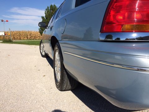 2003 Ford Crown Victoria - Rear quarter view of a light blue 2003 Ford Crown Victoria, showing the taillight and chrome trim.