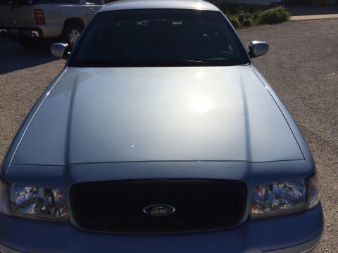 2003 Ford Crown Victoria - The front of a light blue Ford Crown Victoria is shown, parked outdoors with another vehicle in the background.