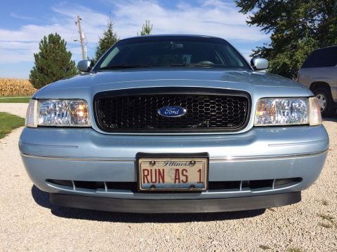 2003 Ford Crown Victoria - Front view of a light blue 2003 Ford Crown Victoria, a black honeycomb grille and an Illinois license plate reading 'RUN AS 1'.