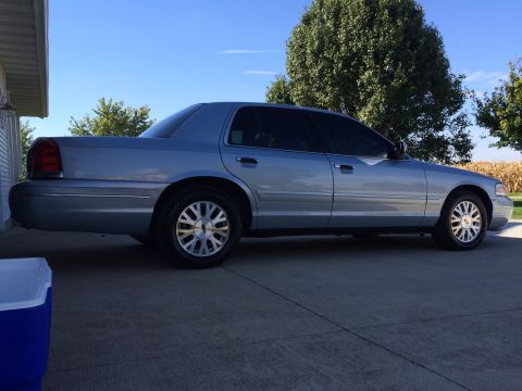 2003 Ford Crown Victoria - A silver 2003 Ford Crown Victoria is parked outside on a sunny day.