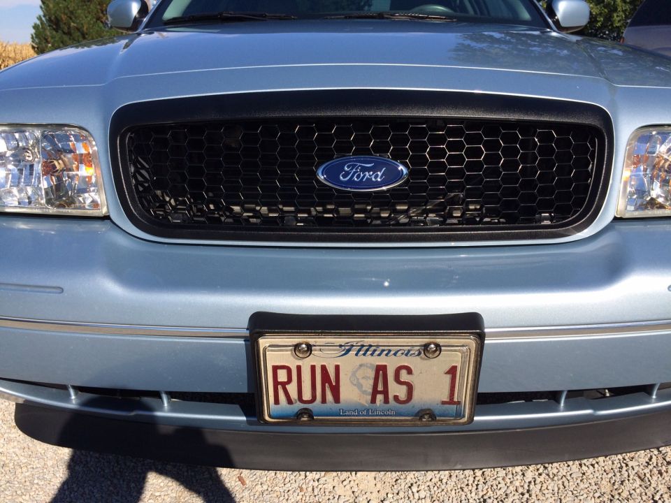 Light blue 2003 Ford Crown Victoria front grille with honeycomb pattern and Illinois license plate 'RUN AS 1'