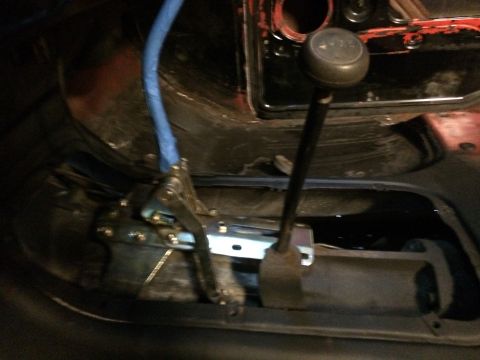 1978 Ford Bronco - Close-up view of the transmission shifter and linkage mechanism within a vehicle's interior.