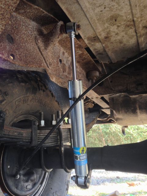 1979 Ford Bronco - Close-up of a vehicle's rear suspension system, highlighting a shock absorber and leaf springs.