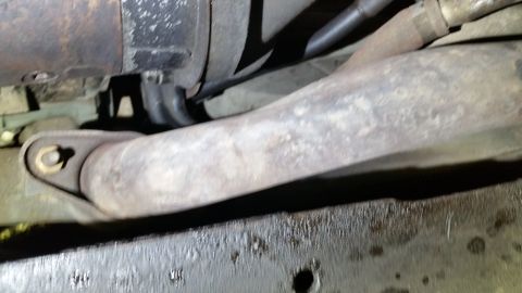 1991 Ford F-250 - Underside view of a vehicle's engine bay, focusing on the exhaust system and starter.