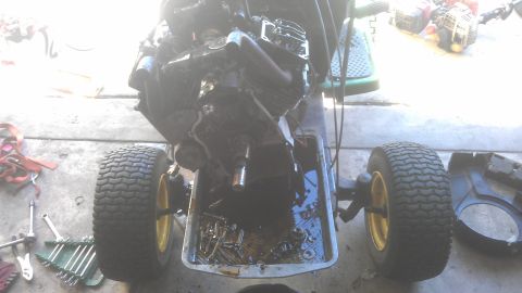 2006 Honda RANCHER - Close-up of a V-twin engine from a lawn mower, with the oil pan detached to reveal the crankshaft and connecting rods.