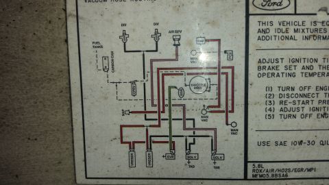 1991 Ford F-250 - Photo of an underhood Ford vacuum hose routing emissions decal showing the color-coded vacuum schematic and tune-up instructions.