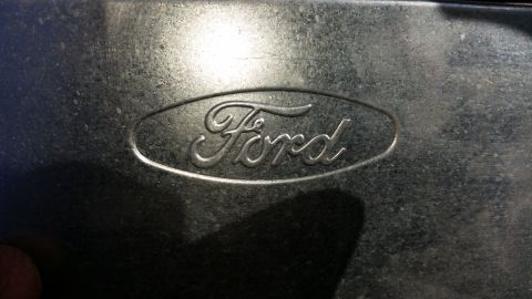 1991 Ford F-250 - Close-up of an embossed Ford logo on a metallic background.