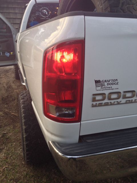 1979 Ford Bronco - A white pickup truck's rear is visible, showing a taillight and a "DODGE HEAVY DUTY" emblem.