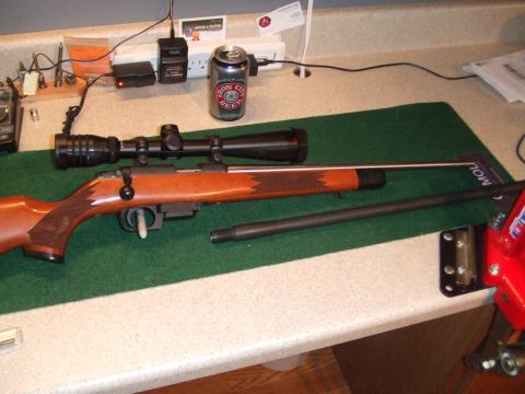 1996 Ford Bronco - Rifle components laid out on a workbench, including a scope and a spare barrel.