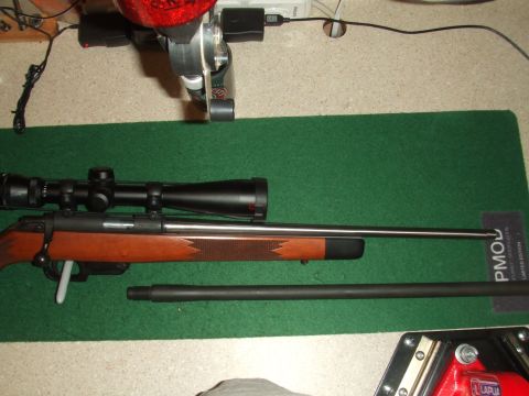 1996 Ford Bronco - A rifle with a scope and an additional barrel are laid out on a green mat, with electronic equipment in the background.