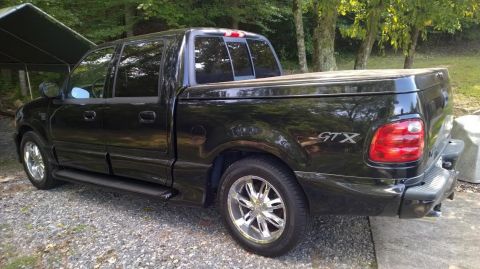 2003 Ford F-150 - This black 2003 Ford F-150 GTX pickup truck is shown from the rear 3/4 angle.