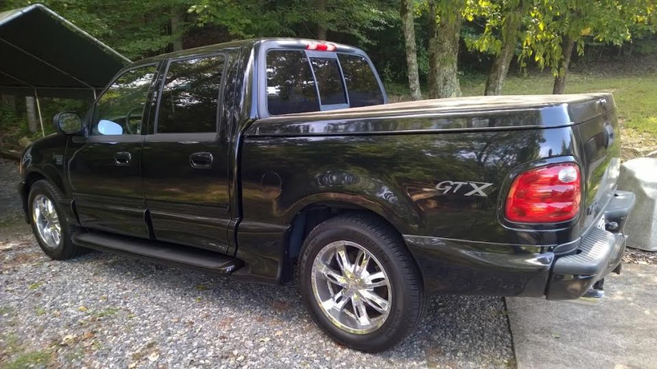 Black 2003 Ford F-150 GTX pickup truck, rear 3/4 view