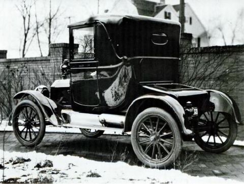 1915 Ford Model T - A 1915 Ford Model T coupe with its soft top up is parked outdoors on a snowy day.