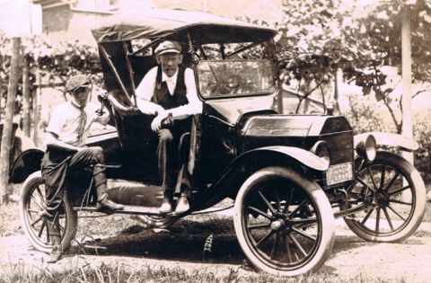 1915 Ford Model T - Two men pose with a 1915 Ford Model T, a classic automobile from the early 20th century.