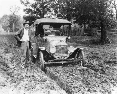 1915 Ford Model T - A muddy road proves too much for this early automobile, leaving it stuck with a driver and passenger.