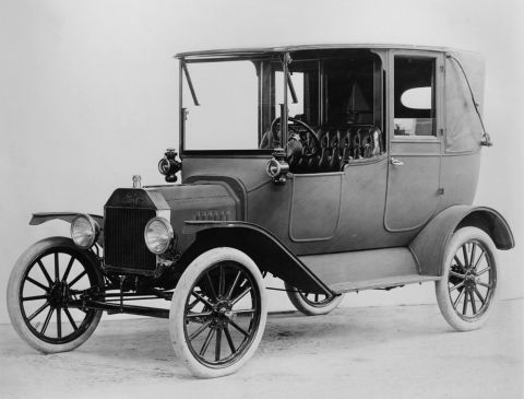 1915 Ford Model T - A 1915 Ford Model T touring car is shown in a studio setting with a 3/4 front view.