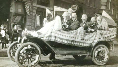 1915 Ford Model T - A 1915 Ford Model T, adorned with patriotic decorations, participates in a parade with several occupants.