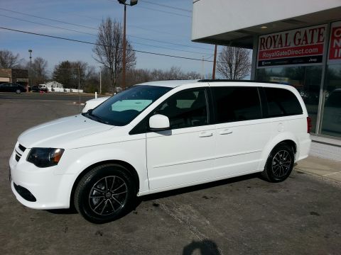 2007 Dodge Durango - White minivan parked outside a dealership under a bright sky.