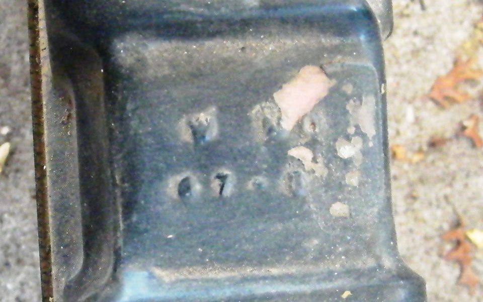 Stamped numbers 07-0 on a dark metal part