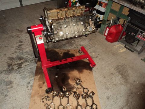 2004 Mercury Grand Marquis - Engine block and associated parts are disassembled and laid out in a garage setting.