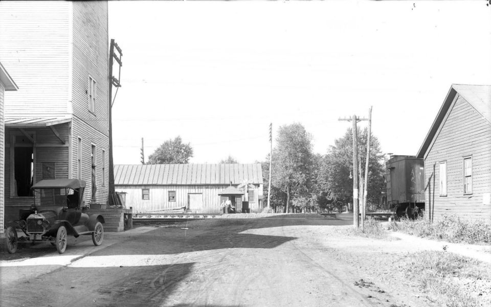 Black 1915 Ford Model T parked next to a building, viewed from the front-left