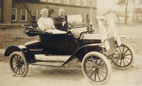 1915 Ford Model T - A couple poses in a 1915 Ford Model T touring car adorned with American flags.