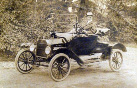 1915 Ford Model T - A 1915 Ford Model T runabout is shown with a driver in a hat and coat.