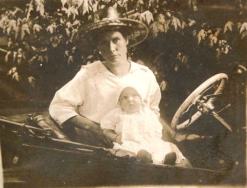 1915 Ford Model T - A woman and a baby pose in a 1915 Ford Model T, likely a runabout model.
