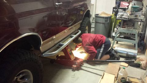 1996 Ford Bronco - Test fitting and marking holes for drilling. My son grinding the front body mount to fit the slider mounting plate