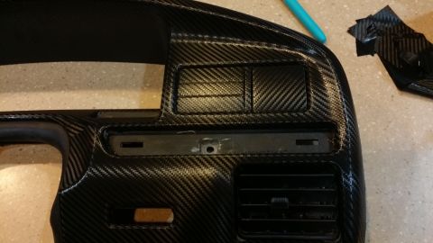 1995 Ford Bronco - Close-up of a vehicle's interior dashboard trim with a carbon fiber finish.