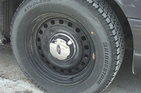 1991 Ford LTD Crown Victoria - A close-up view of a Ford vehicle's wheel and tire, a Bridgestone tire and a Ford-branded hubcap.