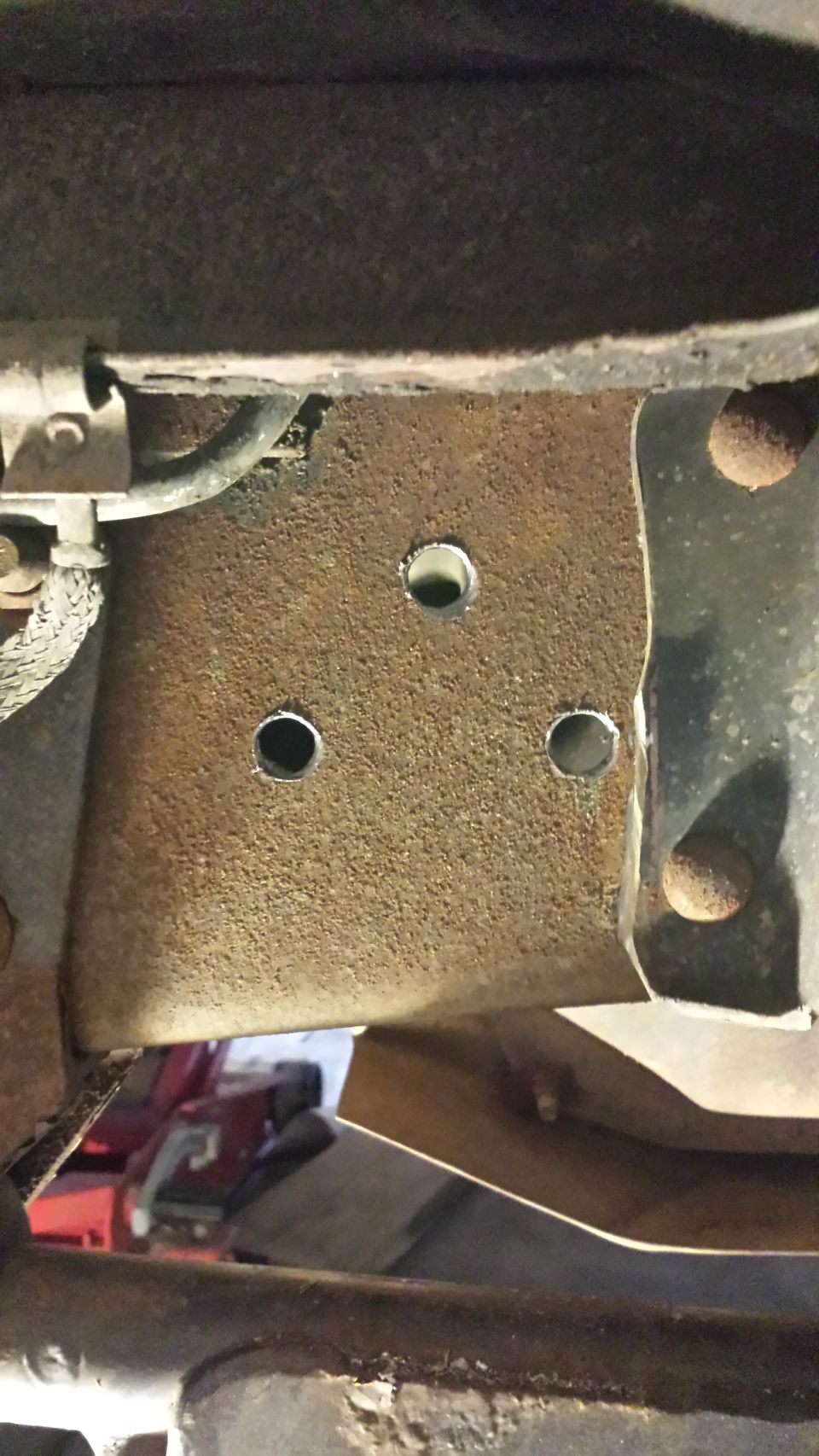 Holes drilled now to clean up the surface rust a bit.  I so love drilling into the frame rail.. :/

You can also see where the body mount has been cut down.