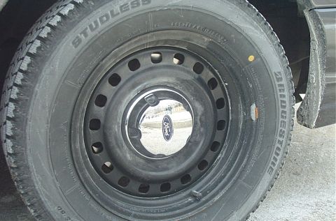 1991 Ford LTD Crown Victoria - A close-up view of a Ford wheel and tire, showing the brand's emblem on the hubcap.