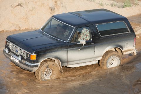 1987 Ford Bronco - This 1987 Ford Bronco is stuck in the mud, showing its front 3/4 view.