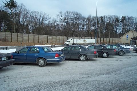 1991 Ford LTD Crown Victoria - Several Ford Crown Victoria sedans, likely police or taxi models, are parked in a lot during winter.
