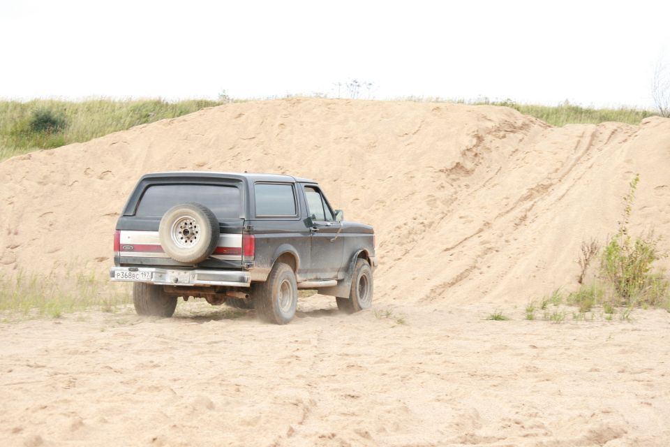 1987 Ford Bronco rear view driving on sand