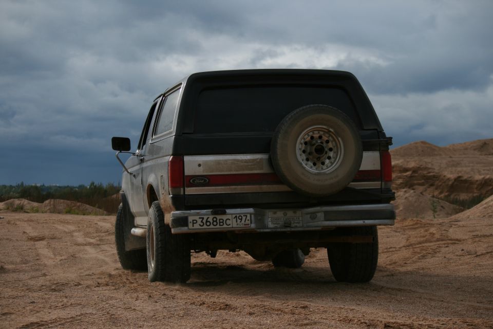 1987 Ford Bronco rear view, spare tire on back, on dirt road
