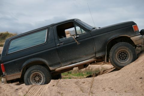 1987 Ford Bronco - This 1987 Ford Bronco navigates a sandy incline, its off-road capabilities.