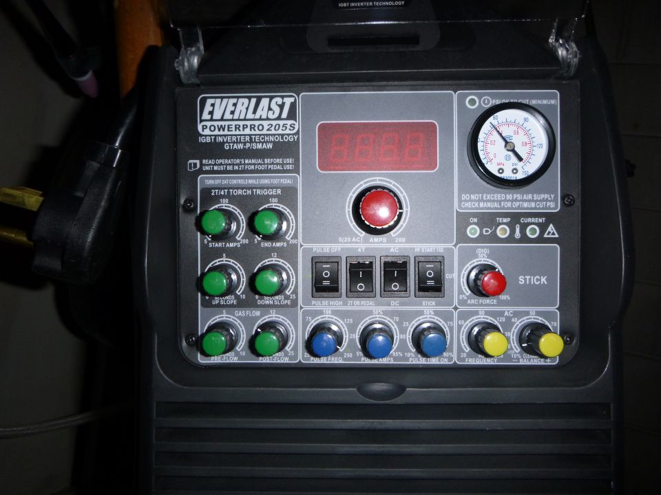Everlast PowerPro 205S welding machine control panel with digital display, pressure gauge, and numerous knobs and switches