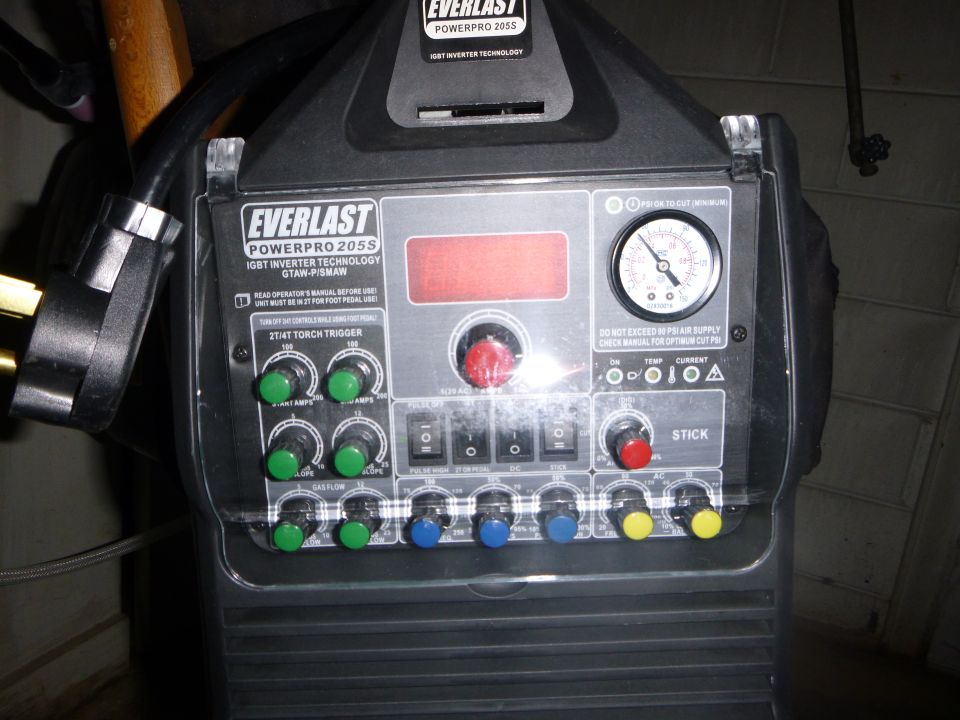 Close-up of an Everlast Powerpro 205S welder control panel with various knobs, switches, and a pressure gauge