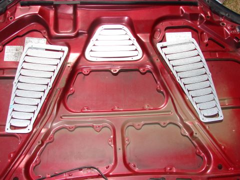 1993 Mazda MX-3 - Aftermarket hood vents are installed on the underside of a car's hood.