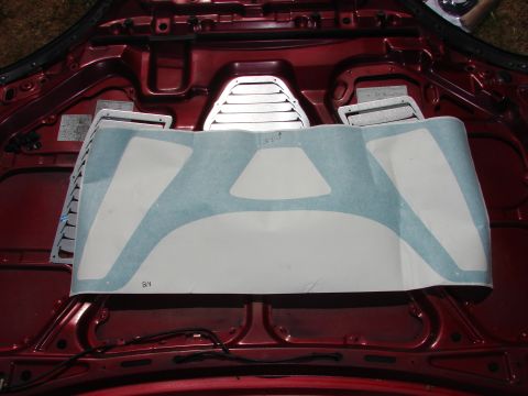1993 Mazda MX-3 - Underside of a car hood showing louvers and a large decal, with some VIN plates visible.