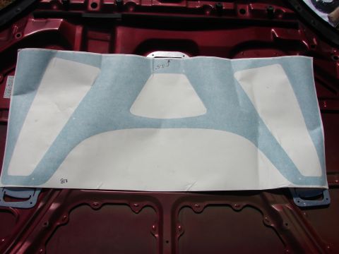 1993 Mazda MX-3 - Hood insulation with cutouts, marked '8N' and 'S.2.5', laid on a red car hood.