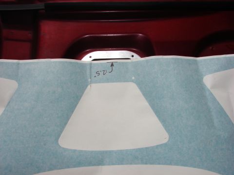 1993 Mazda MX-3 - A template with cutouts is shown against a red car's hood area, with a measurement indicated.