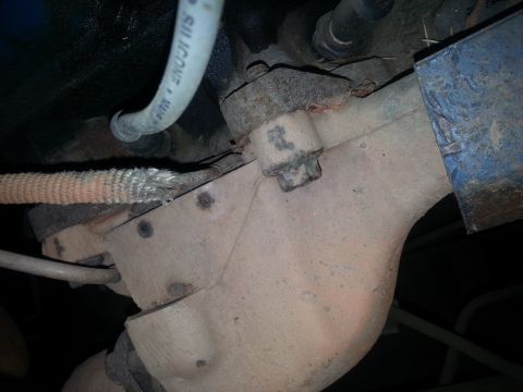 1973 Ford F-100 - Detail of engine components including exhaust manifold and a silicone hose.