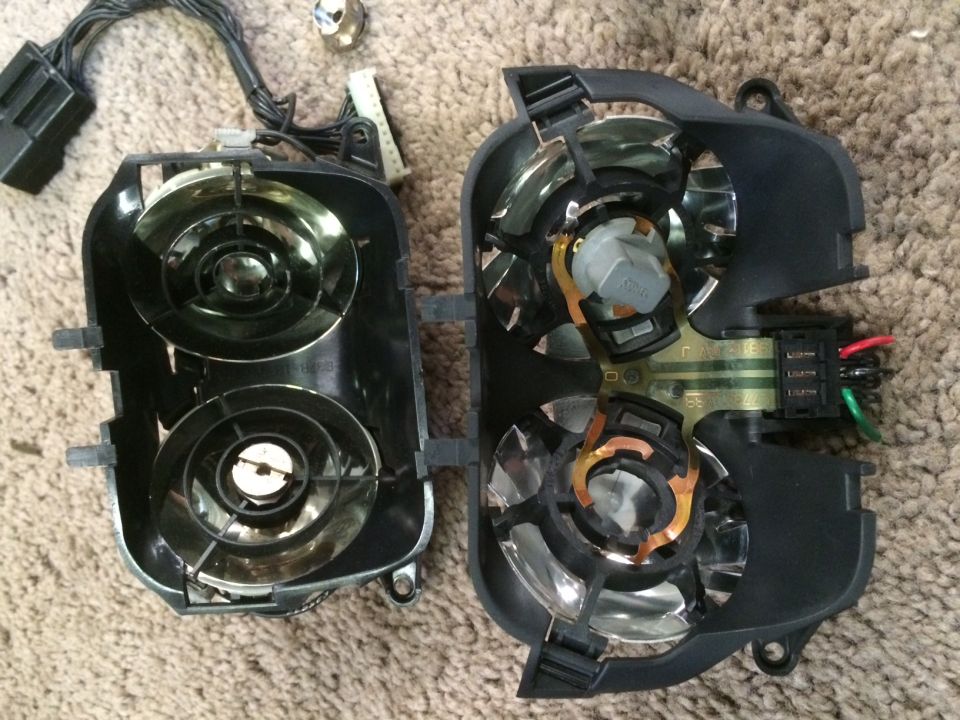 Two disassembled headlight assemblies with wiring harnesses and connectors