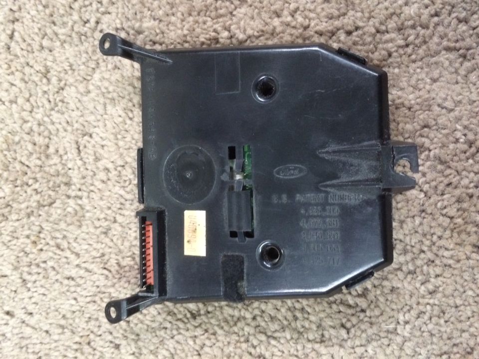 Black Ford electronic control module with orange connector and patent numbers stamped on casing