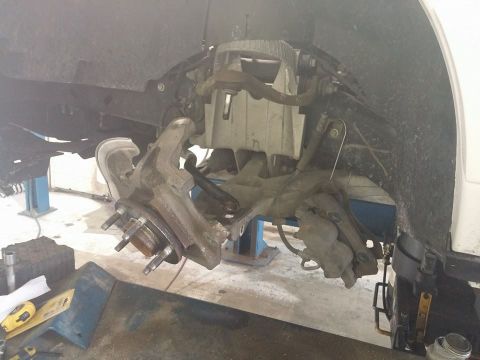 2000 Mercury Grand Marquis - Front suspension assembly removed from a vehicle, showing the hub, brake caliper, and control arms.