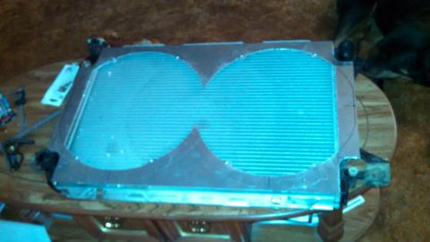 1967 Ford F-250 - Radiator assembly with dual fan mounts sits on a table, likely for a custom build or repair.